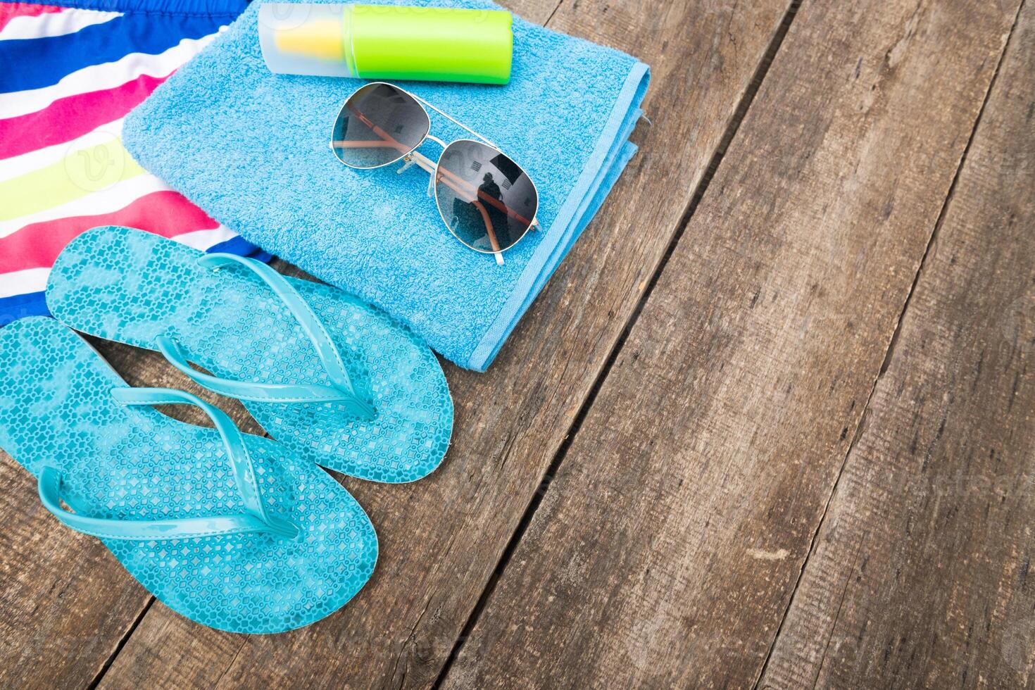 Bright summer essentials laid out on a wooden surface ready for a day at the beach or pool photo