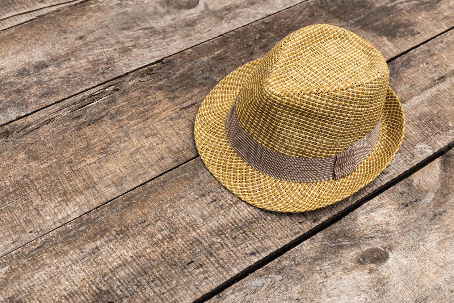 Stylish yellow fedora hat resting on rustic wooden surface in a warm light setting photo