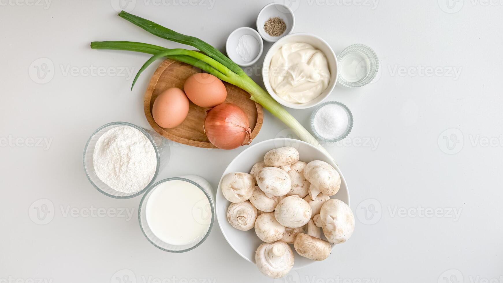 Assorted fresh ingredients including eggs, mushrooms, and dairy products are neatly arranged, ideal for cooking or Easter recipes photo