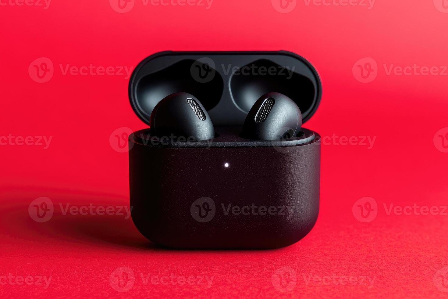 Sleek black wireless earbuds on red background photo