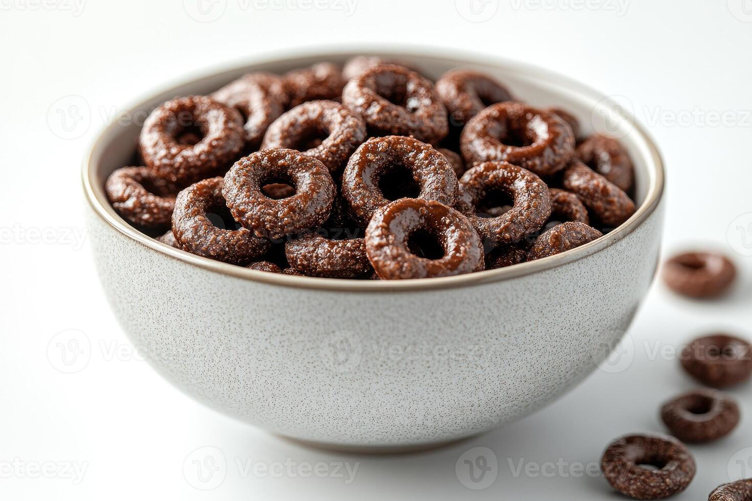 Chocolate cereal rings filling a bowl on white background photo