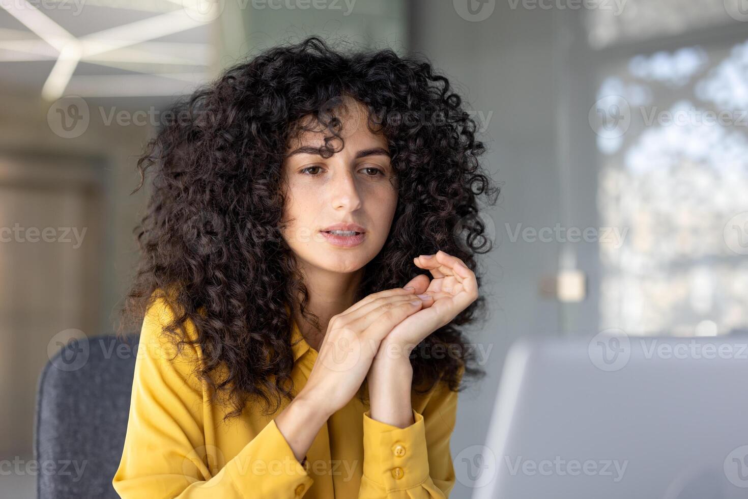 Thinking woman at workplace inside office working with laptop. Serious businesswoman reading data from computer screen close-up and watching educational course. photo