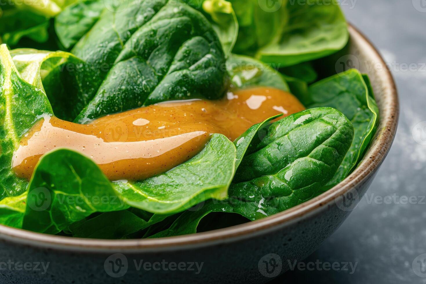 Fresh spinach salad with vinaigrette dressing in a bowl. photo