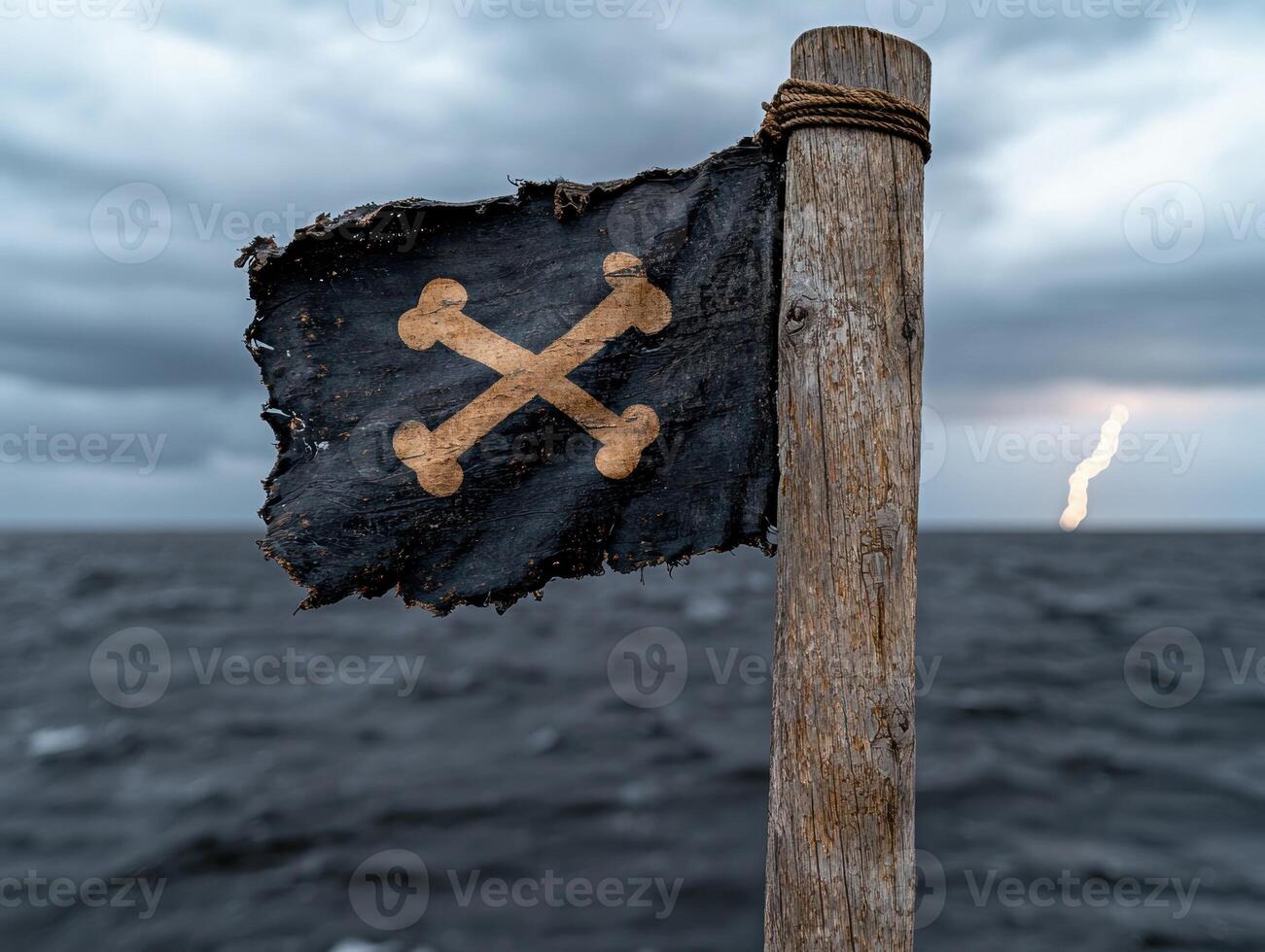 A tattered pirate flag flies on a stormy sea photo