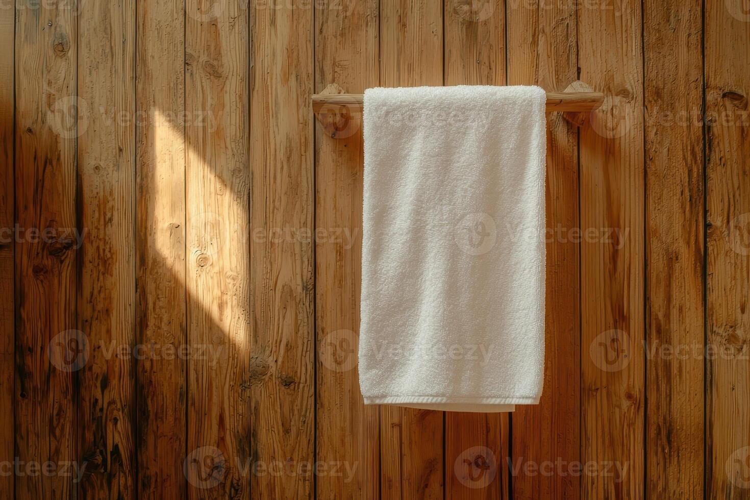 Clean white towel hanging on a wooden rack in a bathroom photo