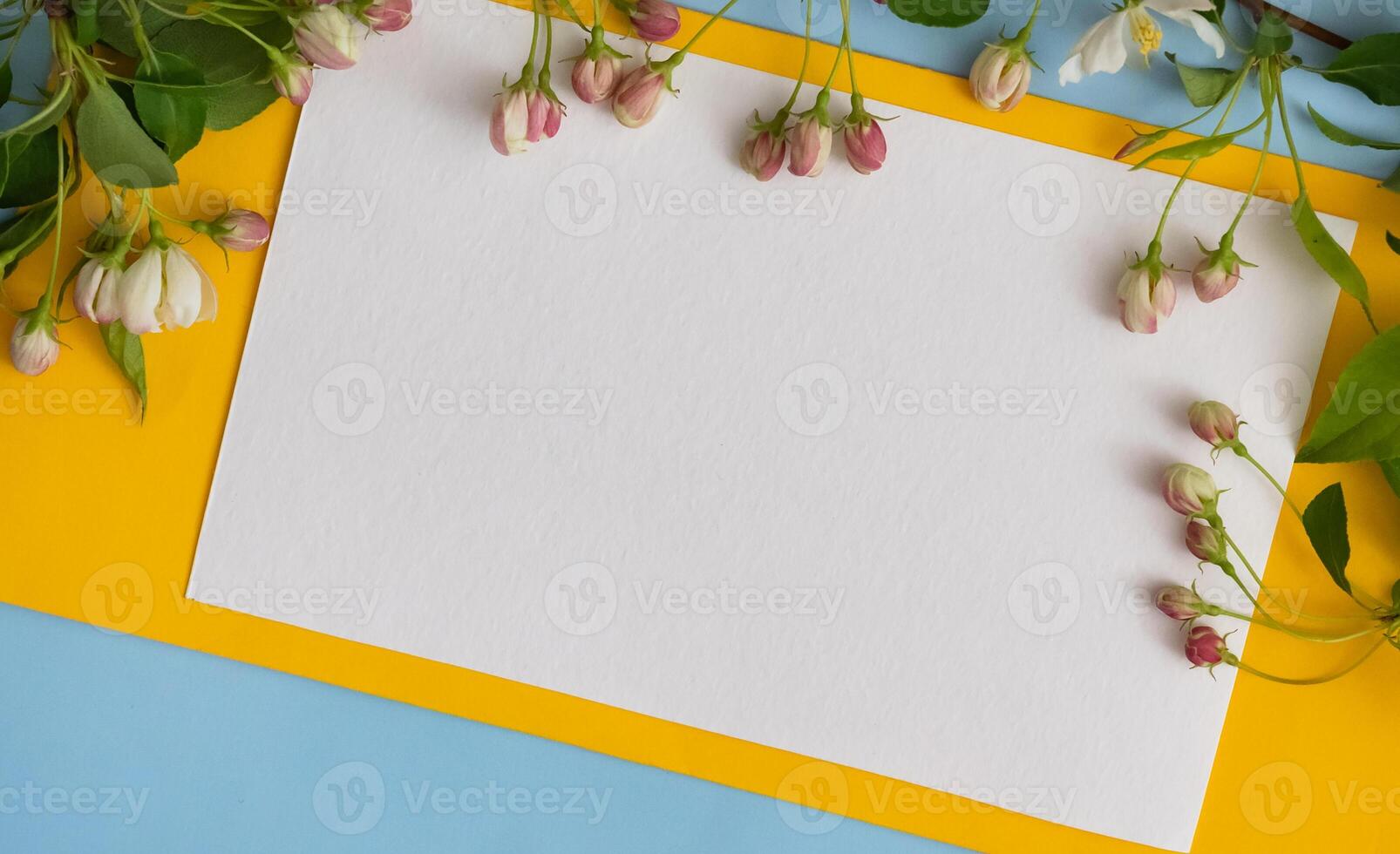 Floral layout on a vintage white wooden background and computer partially. Spring flowers, woman freelancing concept. View from above. photo