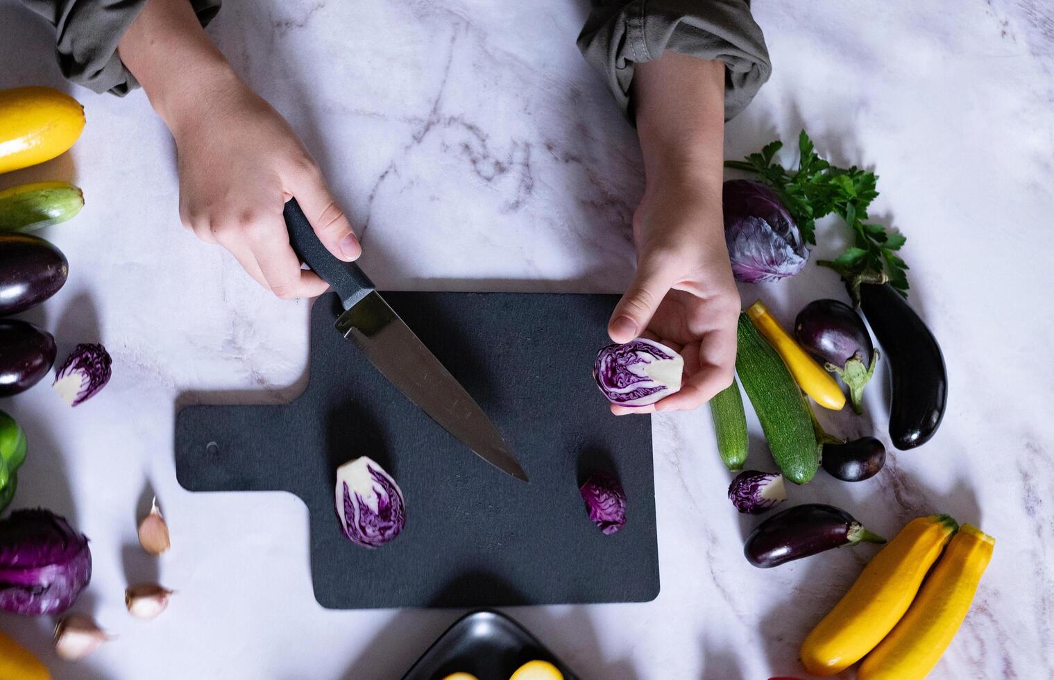 A moment of cooking is captured with hands slicing a squash, hinting at the creation of a healthy meal with fresh ingredients photo