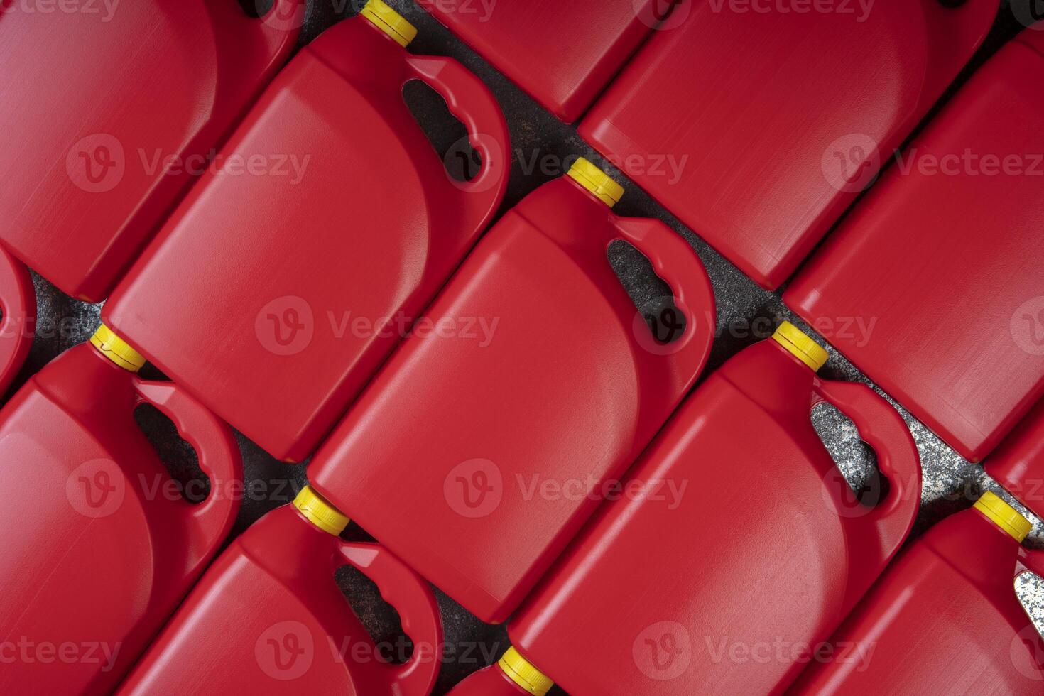 Texture of red plastic motor oil bottles, containers with handle and yellow screw cap photo