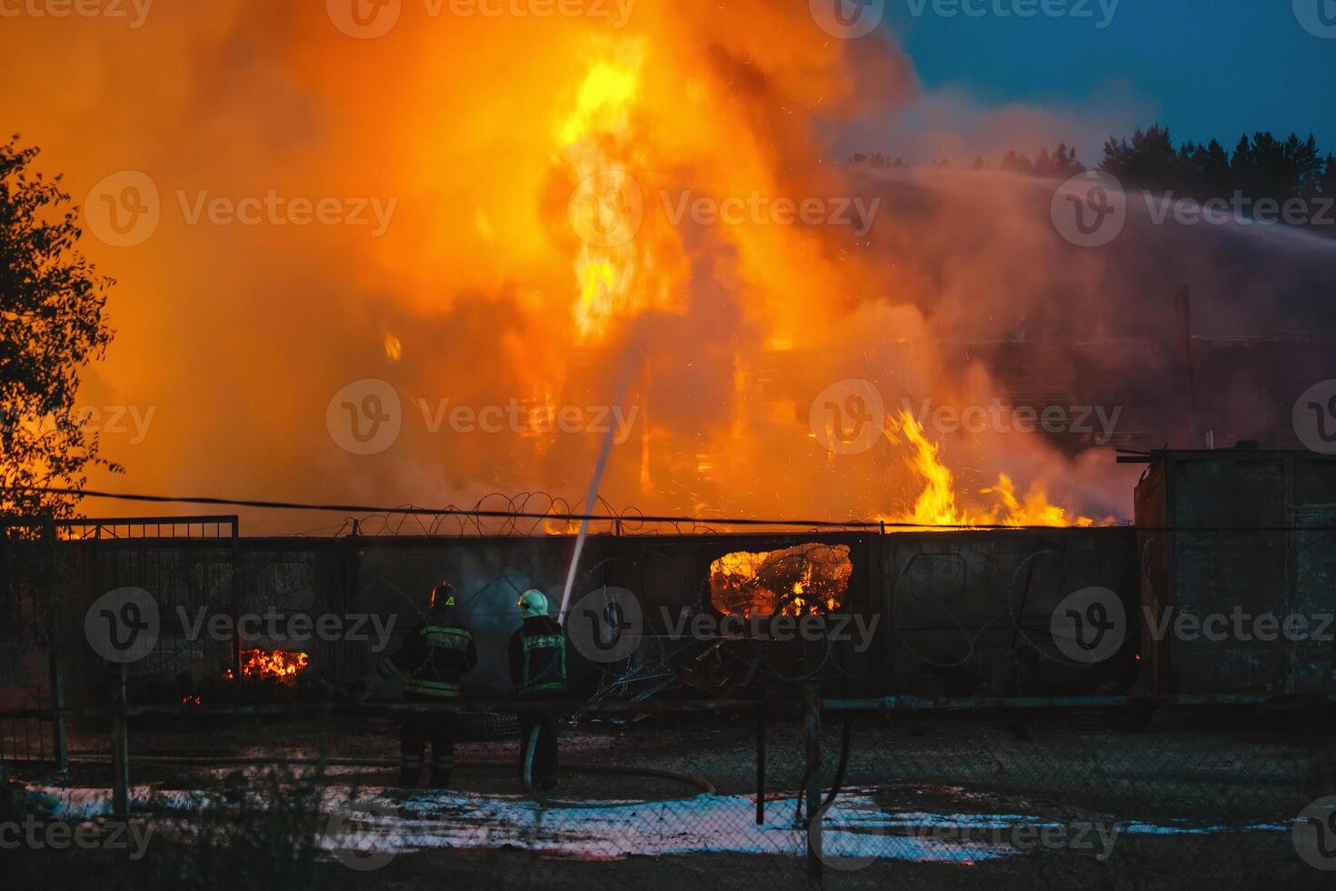 Firefighters extinguish the burning industrial building in the city photo