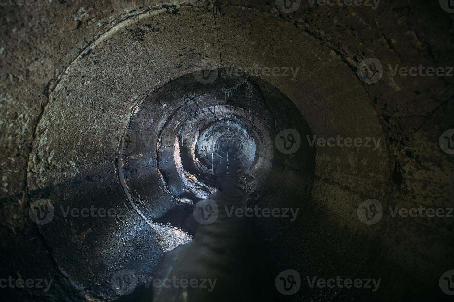 Inside underground urban sewer system. Sewage flowing in round sewer pipe photo