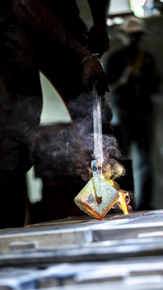 A person is using a metal tool to make a piece of metal photo