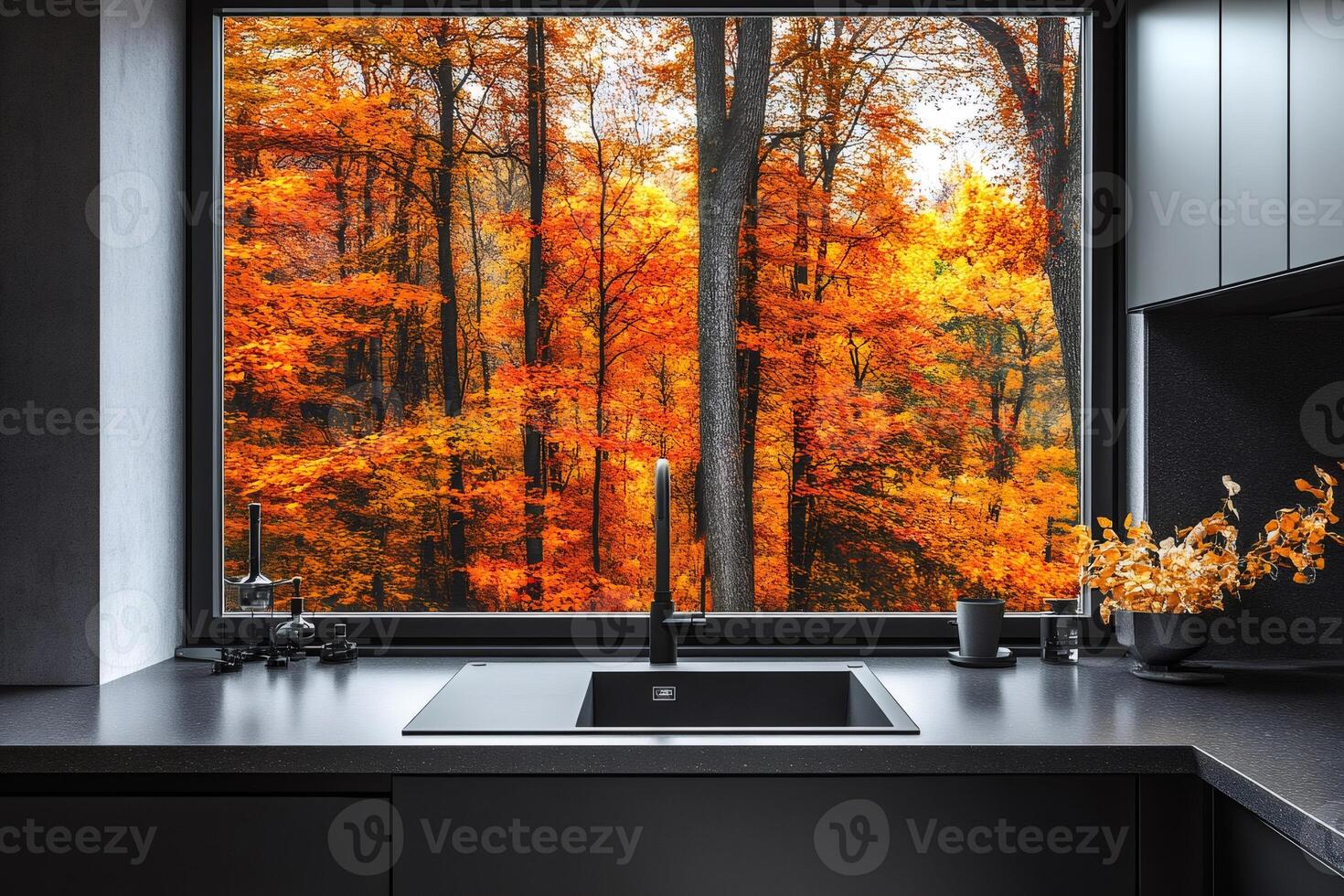 Modern black kitchen sink overlooking stunning autumn forest through large window photo