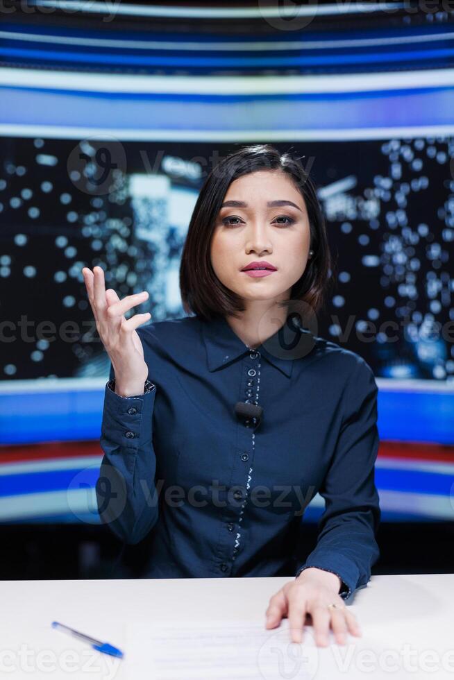 TV show host presenting daily events in newsroom, reading headlines topics from media outlets live on tv network. Asian reporter creating content for international program, broadcast. photo