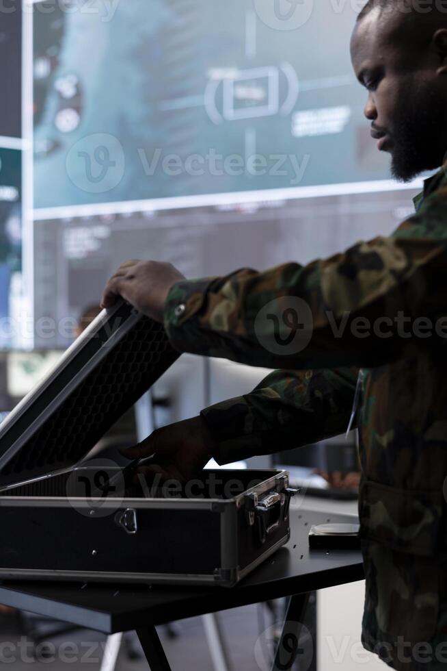 IT expert soldier collecting real time satellite radar data in command post, processing intelligence and coordinating strategic operations to ensure national defense missions. Secret service tower. photo