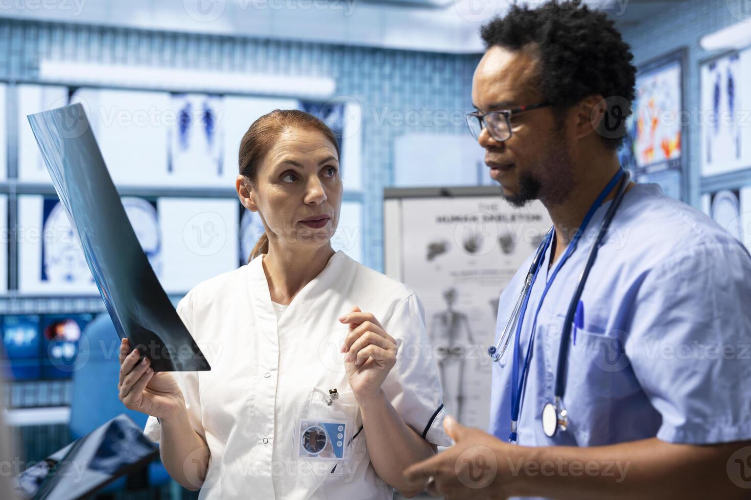 Medical professionals analyzing anatomy x ray scans to find the best treatment, research meeting at facility. Teamwork and expertise in radiology and diagnostics ensure recovery on insurance. photo