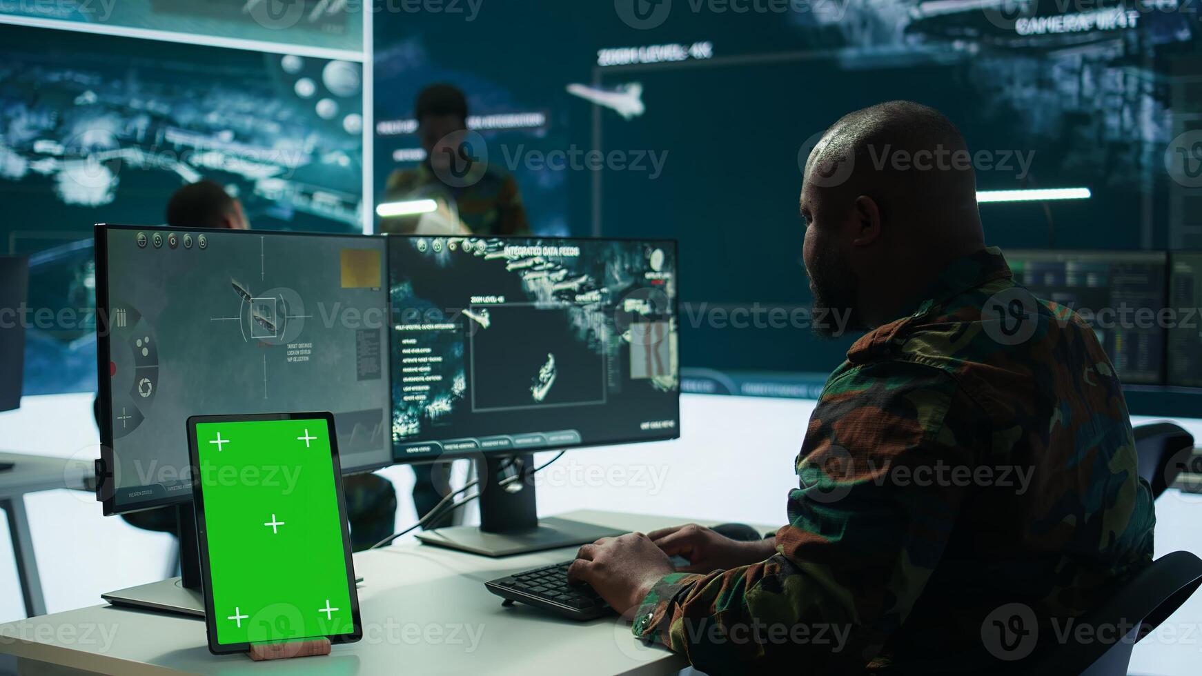 Soldier gathering real time surveillance data next to mockup display in high tech command center, processing intelligence for field operations. Working with modern gear and big screen. Camera B. photo