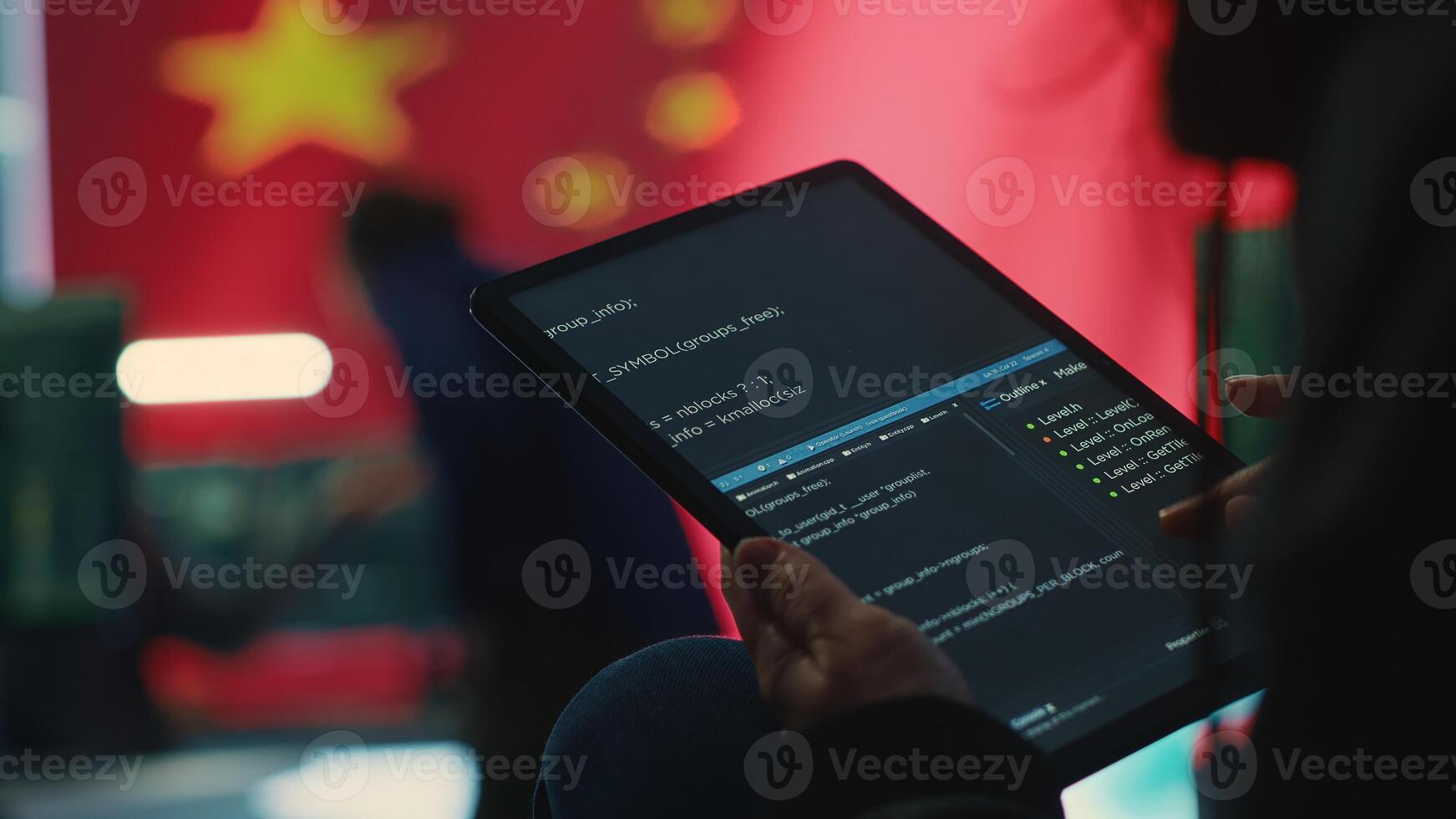 Chinese hacker uses a tablet in governmental cyber operations office to work on hybrid warfare and political manipulation. Inflicting manipulation and propaganda for the communism ideology. Camera A. photo