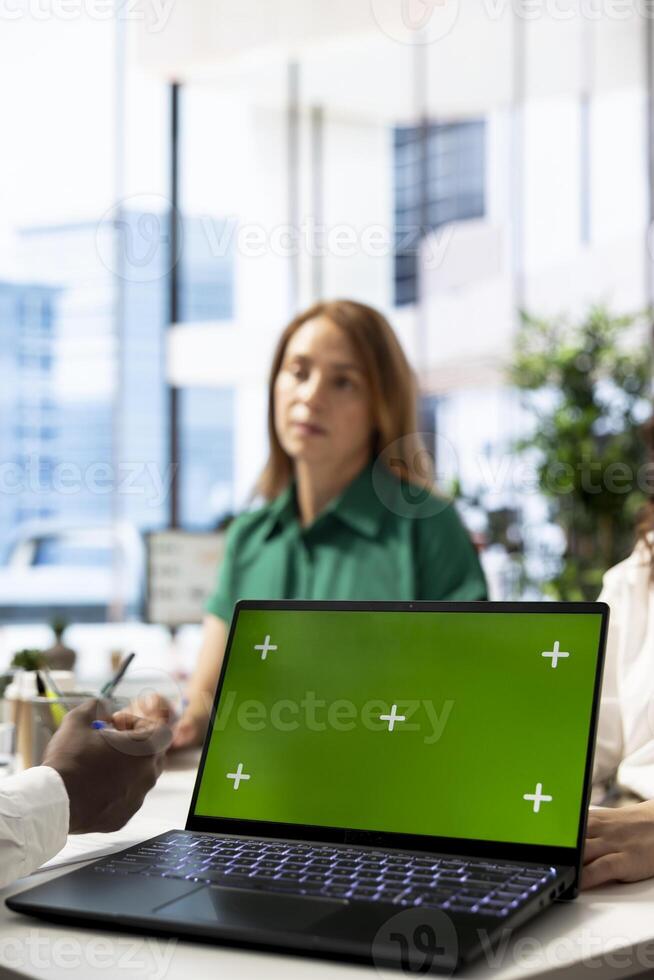 Recruiter using green screen laptop doing interview with person after finding best talent to fill open company position. HR department employee using chroma key notebook, finalizing deal with man photo