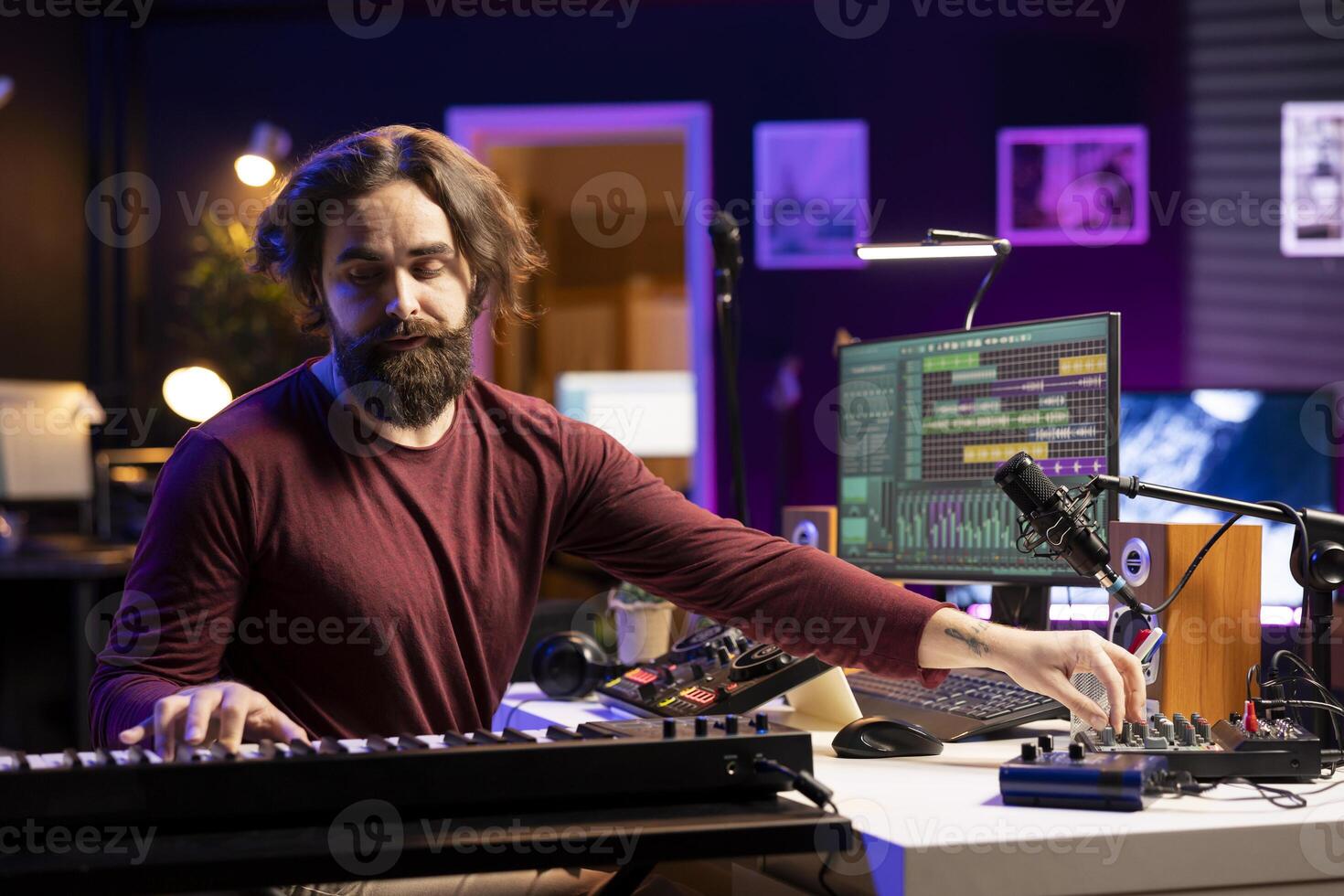 Audio engineer mixing and mastering soundtracks in home studio, adding piano electronic keyboard tunes. Young professional composer creating music with stereo equipment and amplifier. photo
