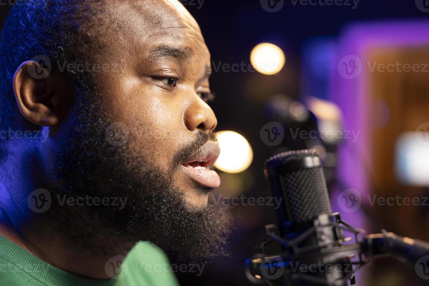 Songwriter singing a new song on his microphone to produce new tracks for music industry, home studio gear. Artist records his voice and own lyrics to edit in mixing and mastering session. Close up. photo