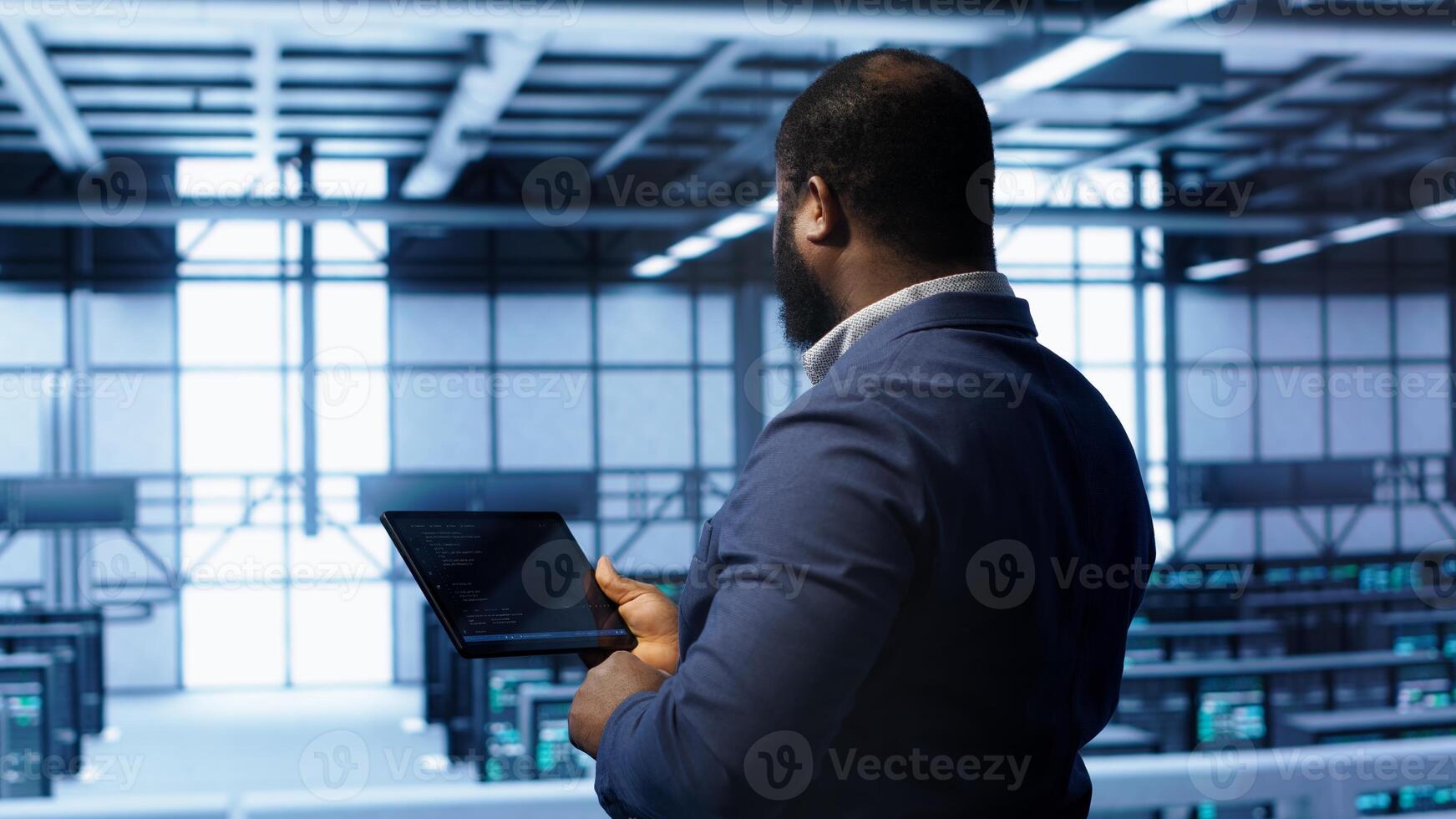 IT operator in server room workspace using tablet to patch network issues affecting transfer rates. Engineer in data center fixing errors affecting server rows rigs, camera A photo