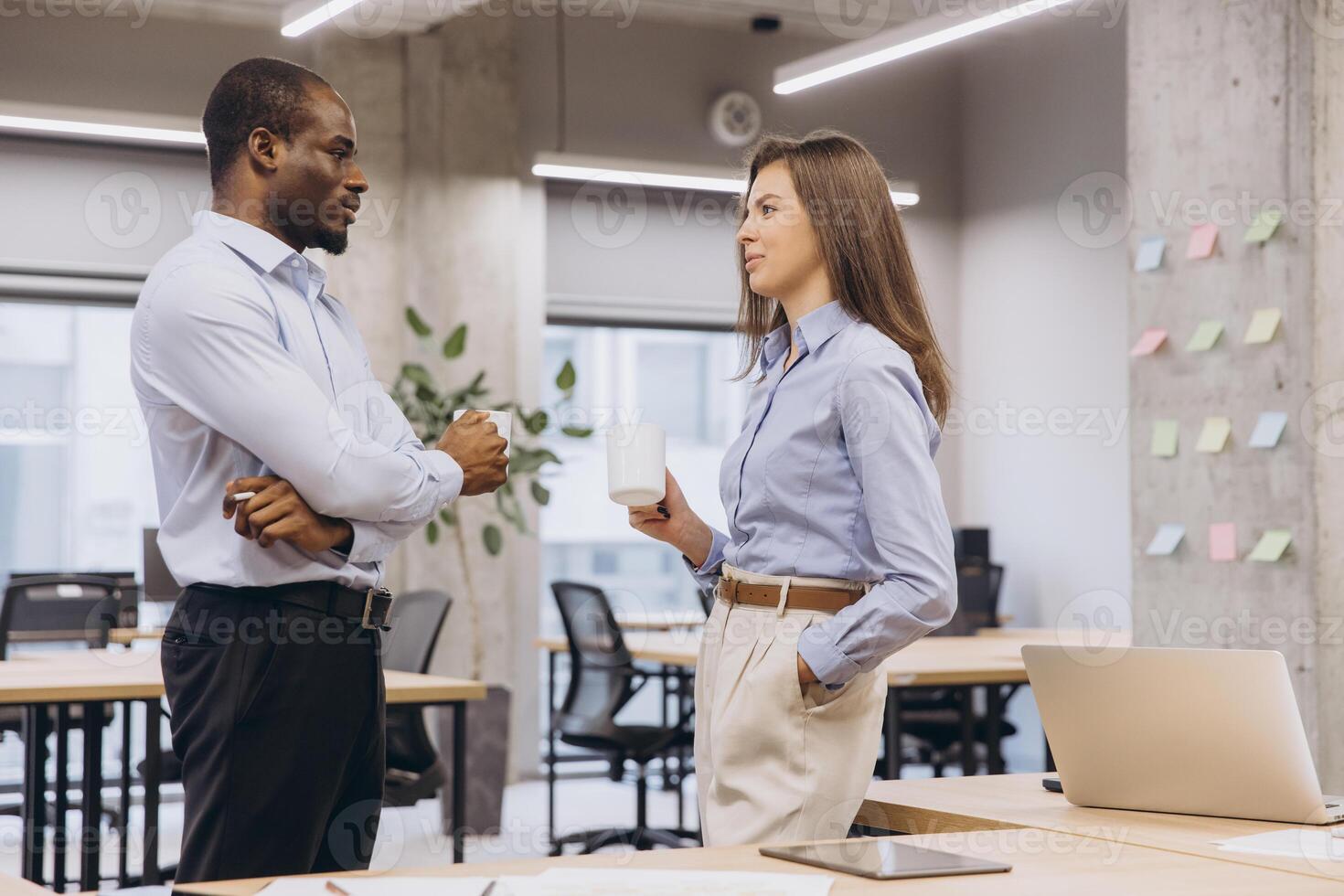 Two managers enjoying a coffee break, engaging in lively discussions and sharing ideas in a vibrant, modern office environment photo