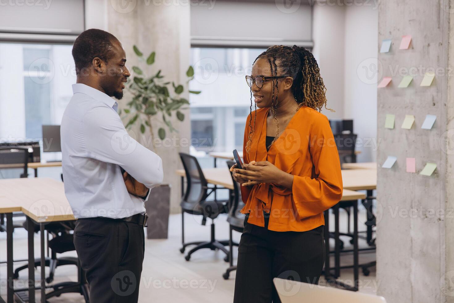 Professional team collaborating, sharing insights on smartphone, brainstorming project details in contemporary workspace photo