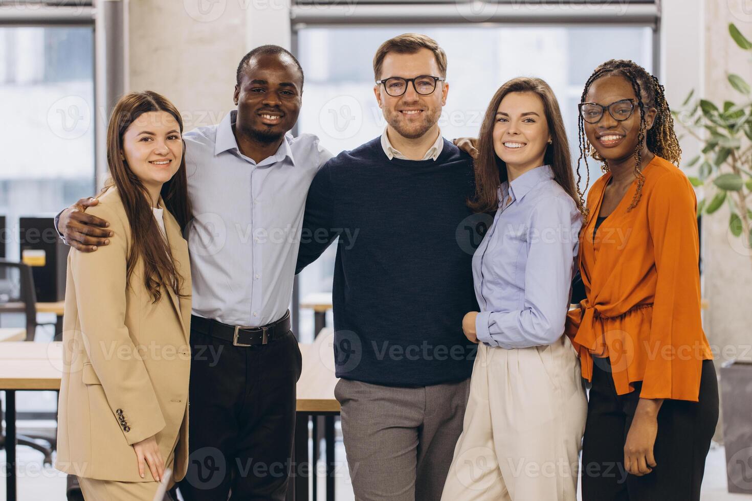 Professional business team bonding, embracing with warm smiles, representing collaborative workplace success in contemporary corporate setting photo