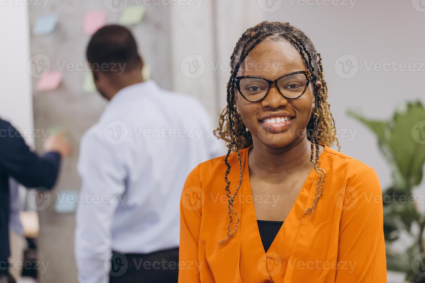 Portrait of smiling african american businesswoman, diverse professionals collaborating, sharing ideas during dynamic team brainstorming meeting in modern office workspace photo