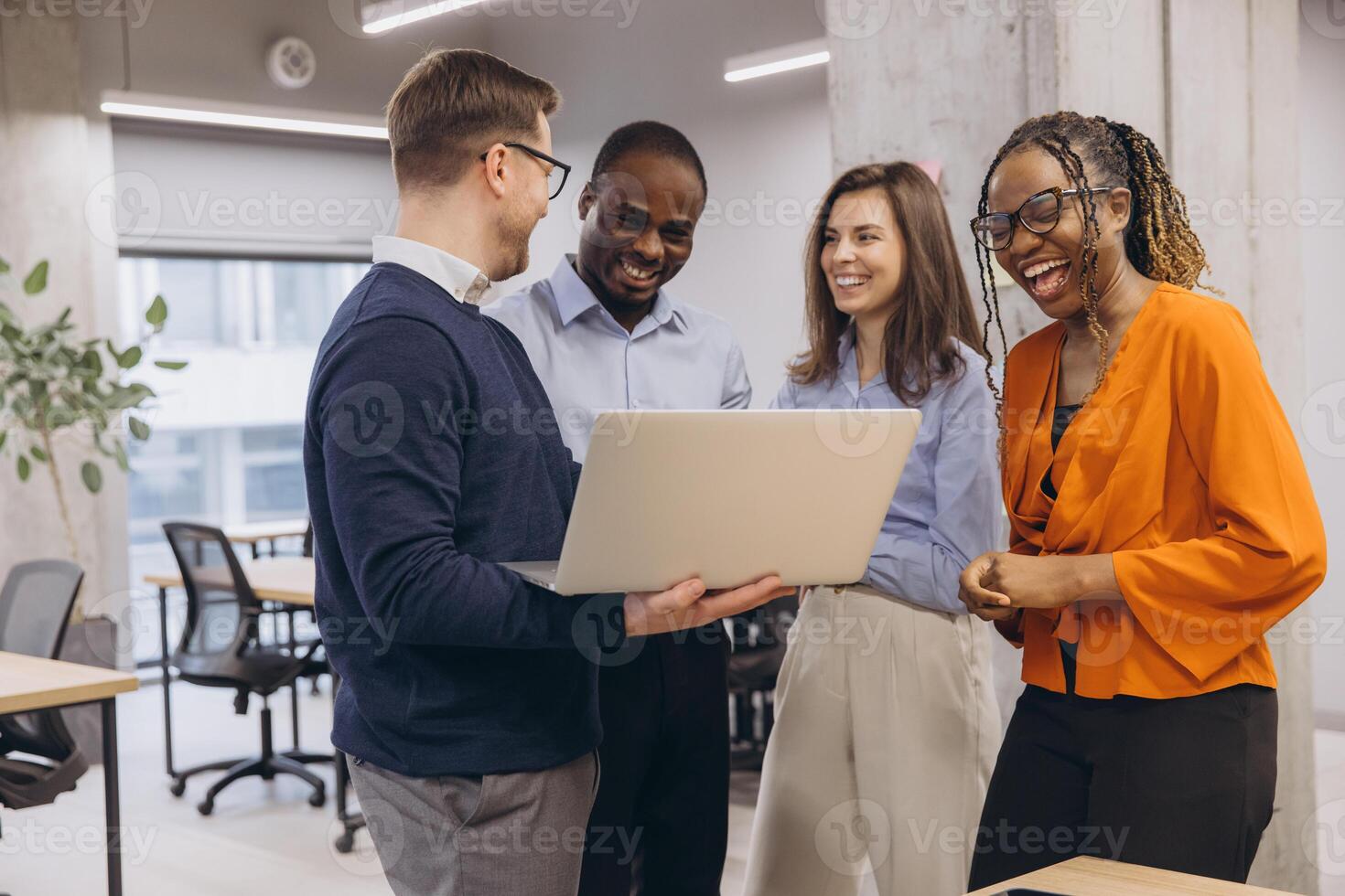 Smiling diverse professionals collaborating, sharing laughter during team project at modern office, embodying workplace camaraderie and inclusivity photo