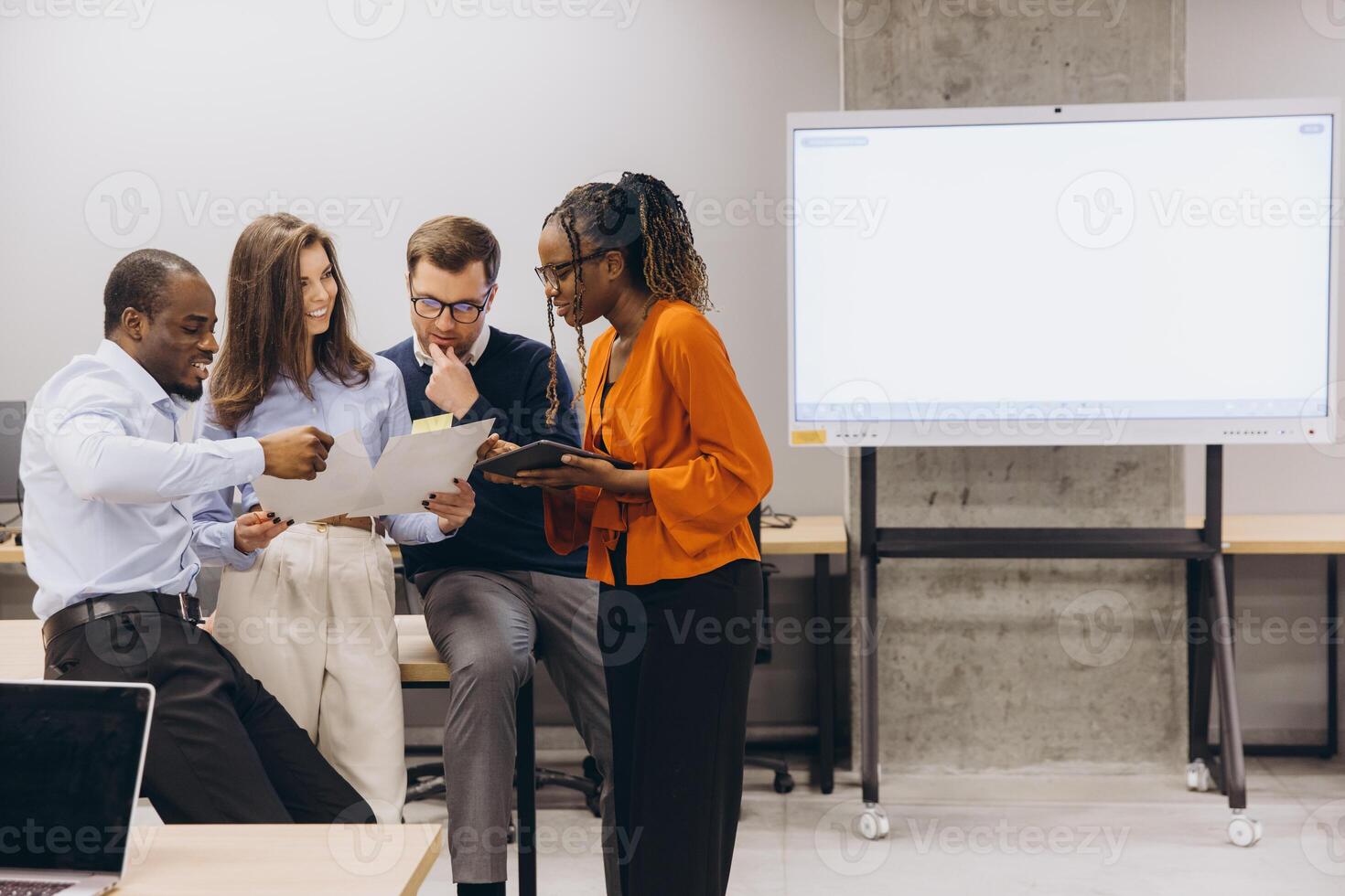 Professional team collaborating, reviewing documents near digital screen in modern workspace with collaborative energy photo