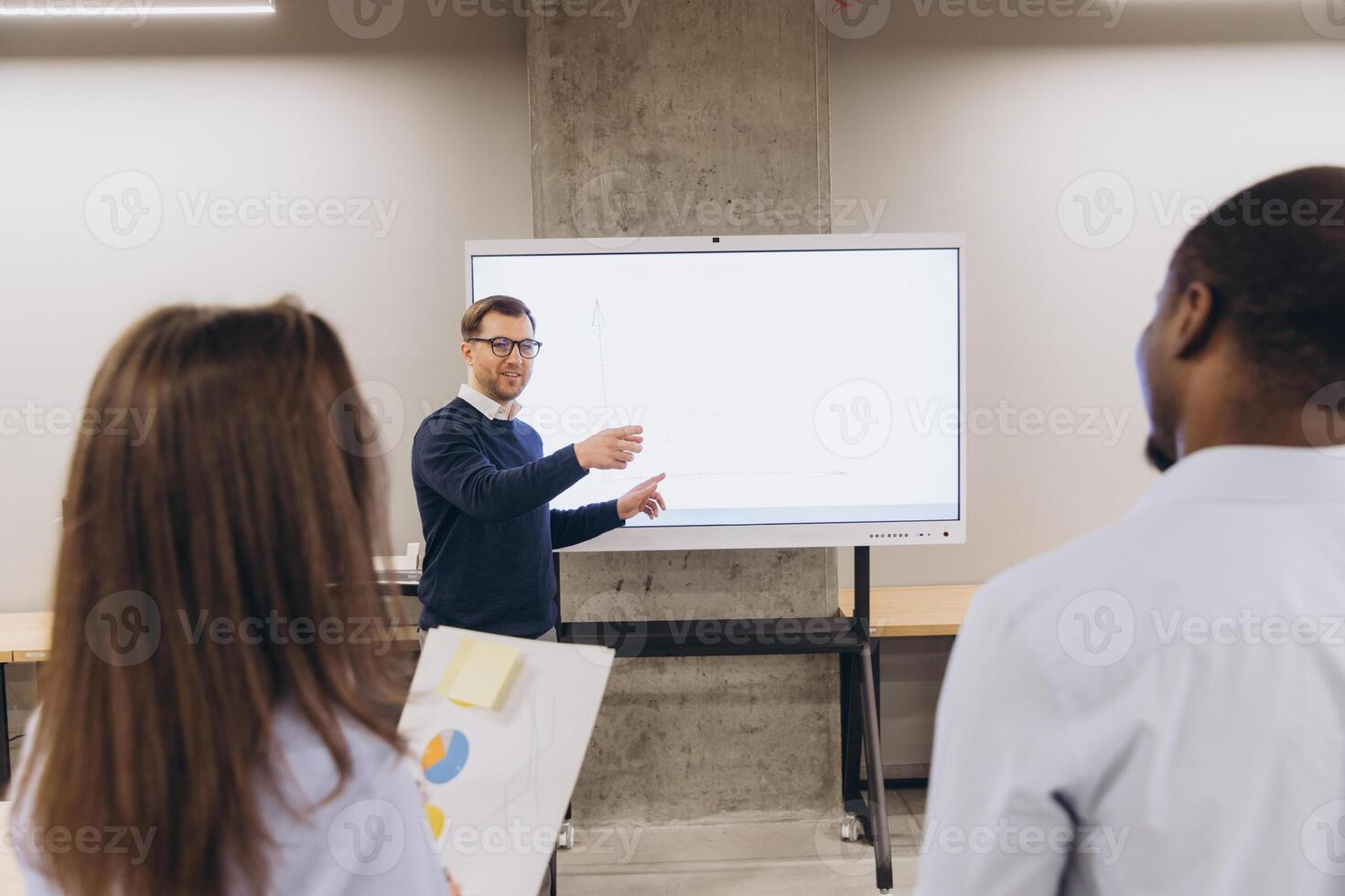 Corporate team analyzing data on digital screen, strategizing together in sleek workspace with collaborative interaction photo