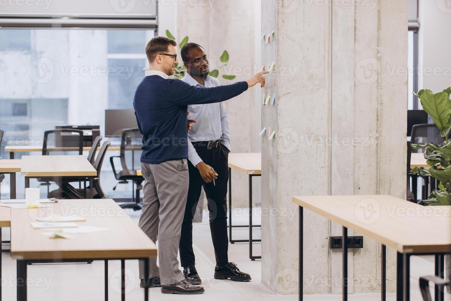 Two professionals discussing ideas in a contemporary office environment, highlighting teamwork and diversity in a business setting photo