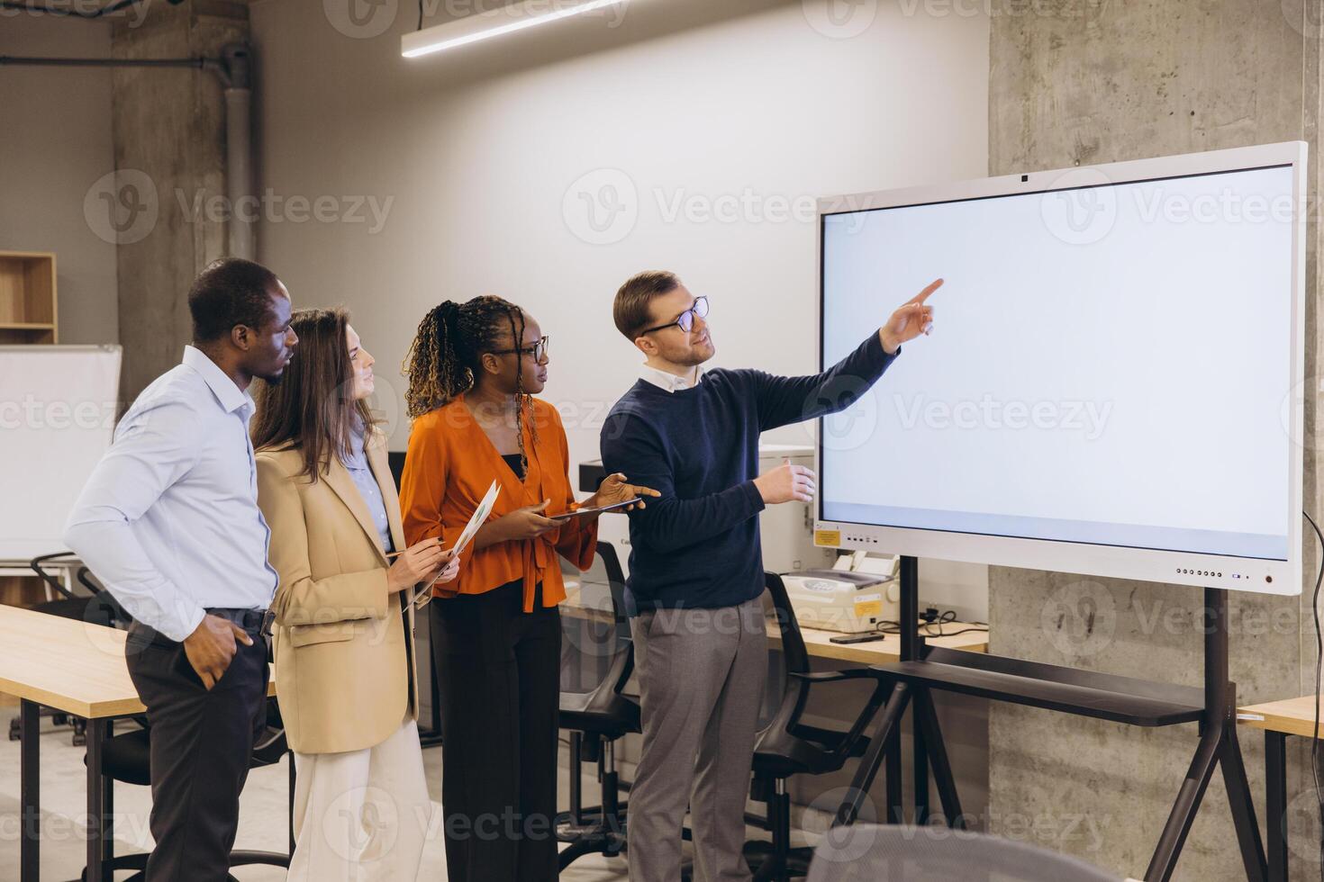 Diverse group of professionals engaging in a collaborative discussion around a digital whiteboard in a modern office setting photo