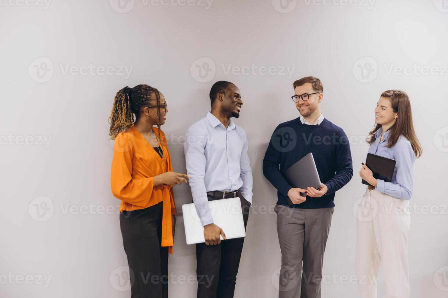 Four professionals engage in a lively discussion, showcasing diversity and collaboration in a modern business environment photo