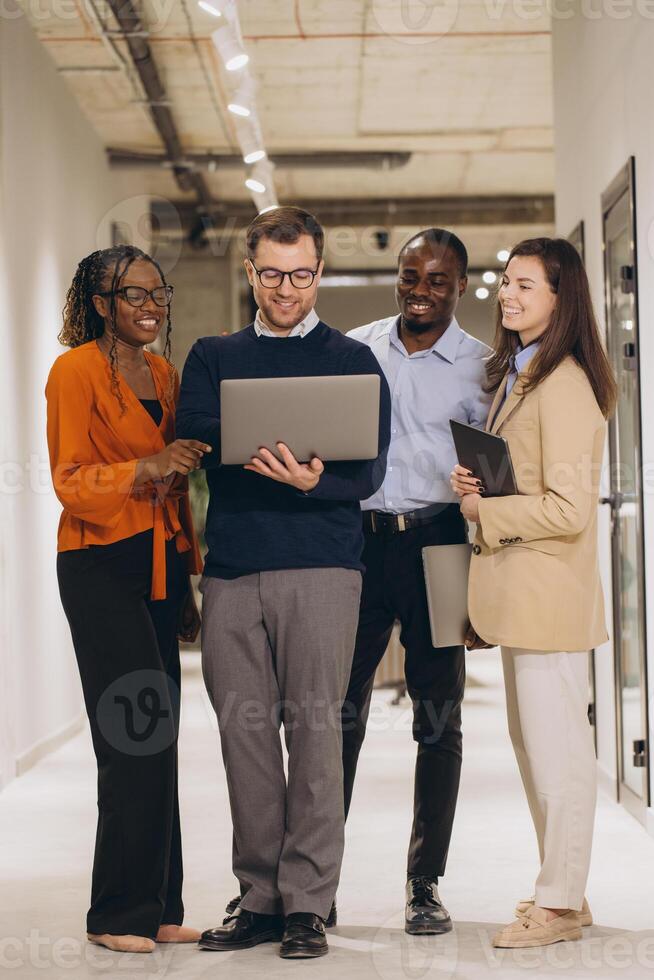 Diverse colleagues working together, sharing ideas and using technology to achieve common goals in a modern workspace photo