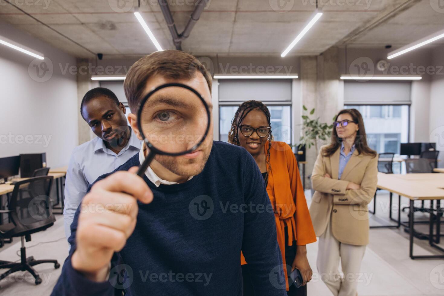 Professional diverse colleagues reviewing financial data, examining documents closely with magnifying glass in sleek workspace photo