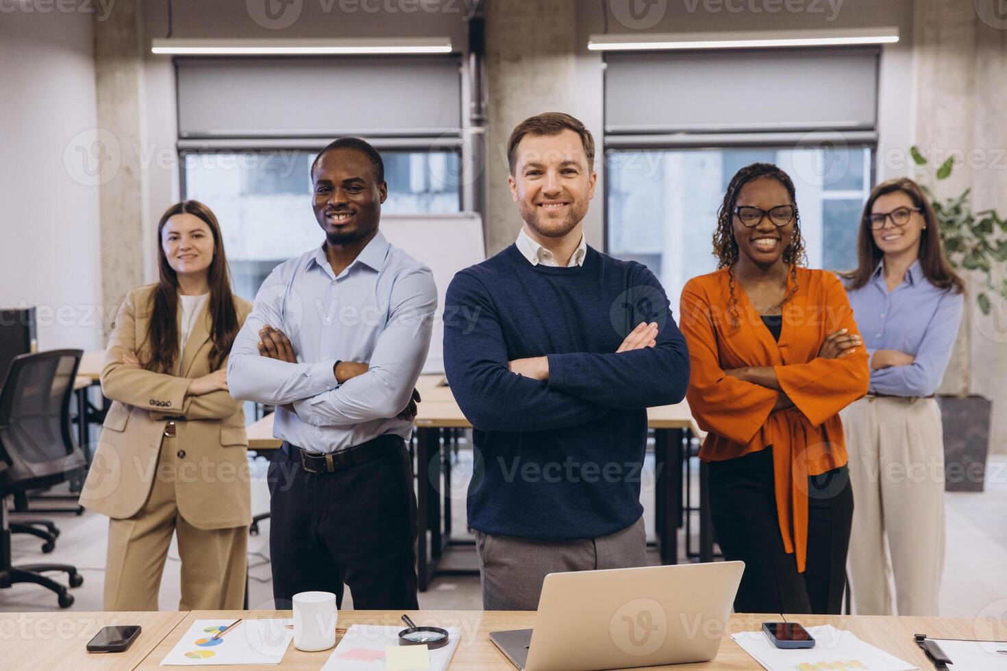 Professional colleagues standing confidently, displaying diverse team unity in modern office environment photo
