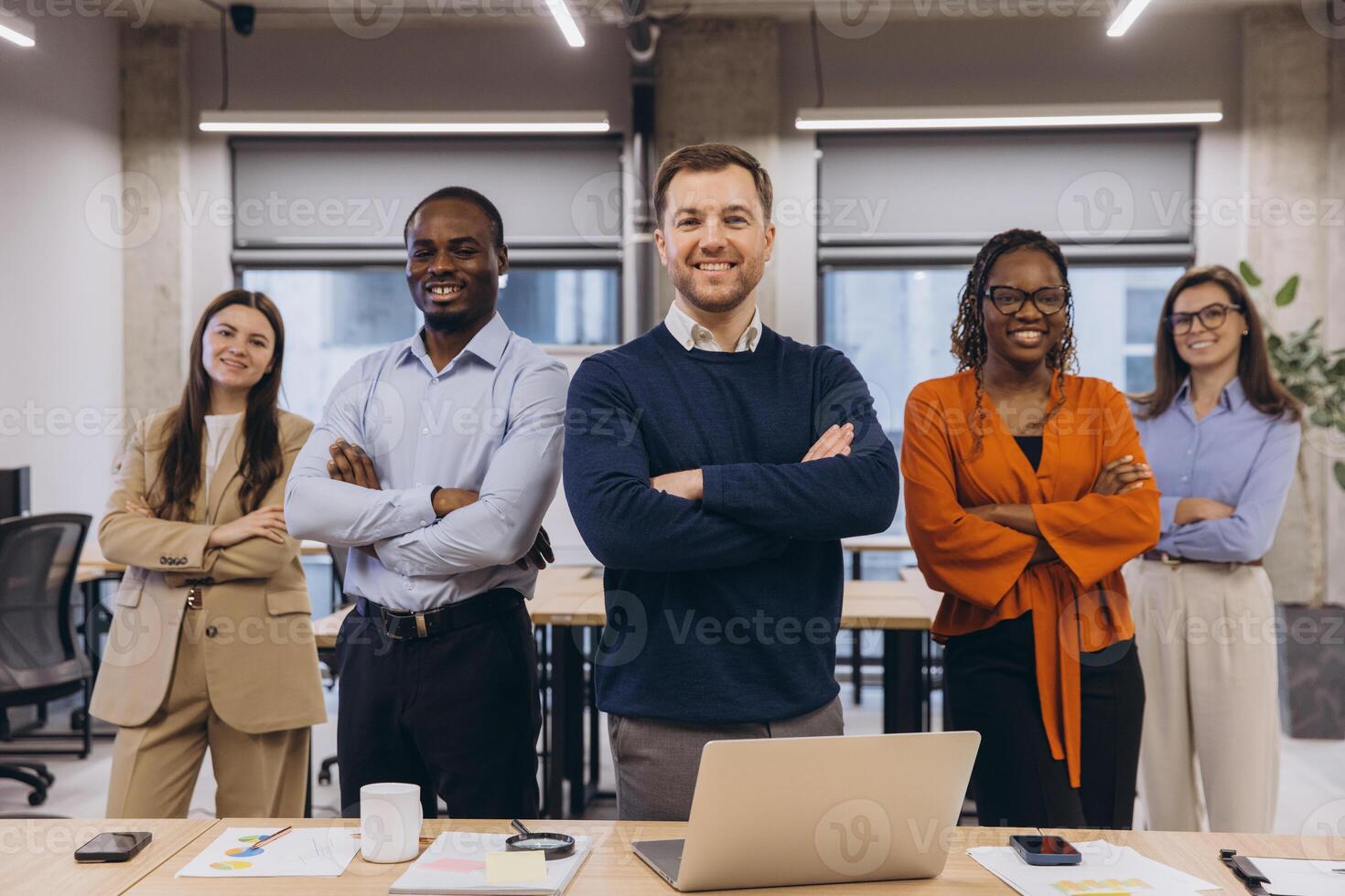 Multi ethnic business team smiling with arms crossed, showing confidence and teamwork in a modern office environment photo