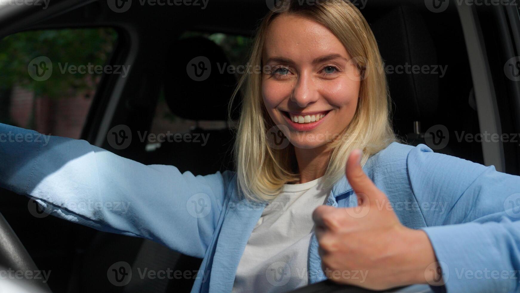 Happy Caucasian businesswoman female woman in car automobile owner fasting seat belt safety girl driver smile demonstrating thumb up in city ride driving test drive auto renting transport buy vehicle photo