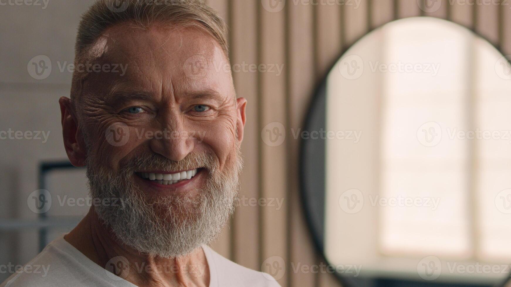 Portrait close up old Caucasian elderly male senior happy smiling toothy mature retired pensioner 60s man smile dental in bathroom indoors home hotel skincare wrinkled face looking at camera carefree photo