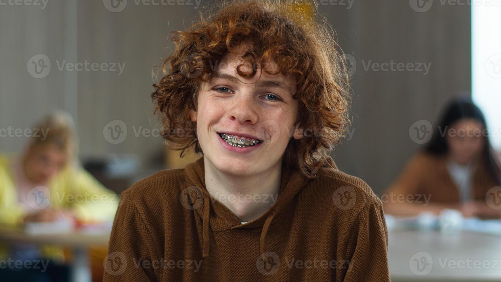 Caucasian happy student teen teenager pupil male boy guy man studying learning at school class university college lesson study learn smiling toothy braces tooth dental medicine smile looking at camera photo