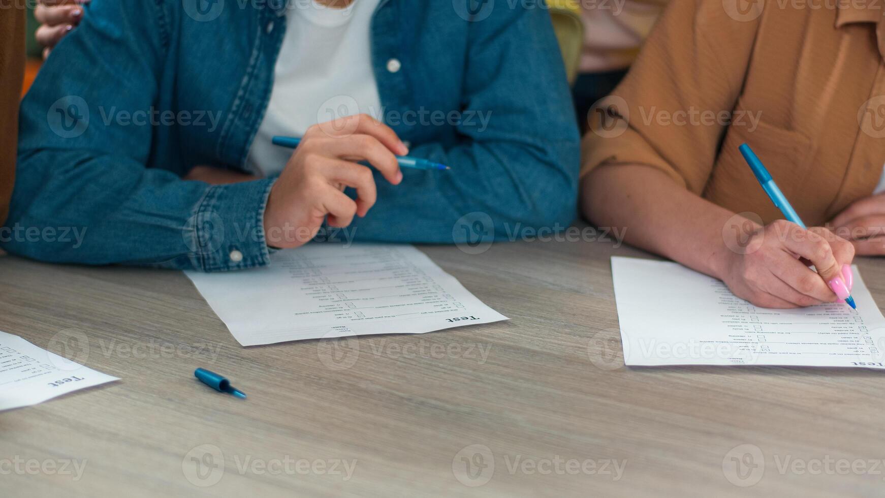 Unrecognizable cropped view close up school Caucasian students learn pupils studying male female write homework teamwork at table study learning men women girls guys writing college test exam write photo