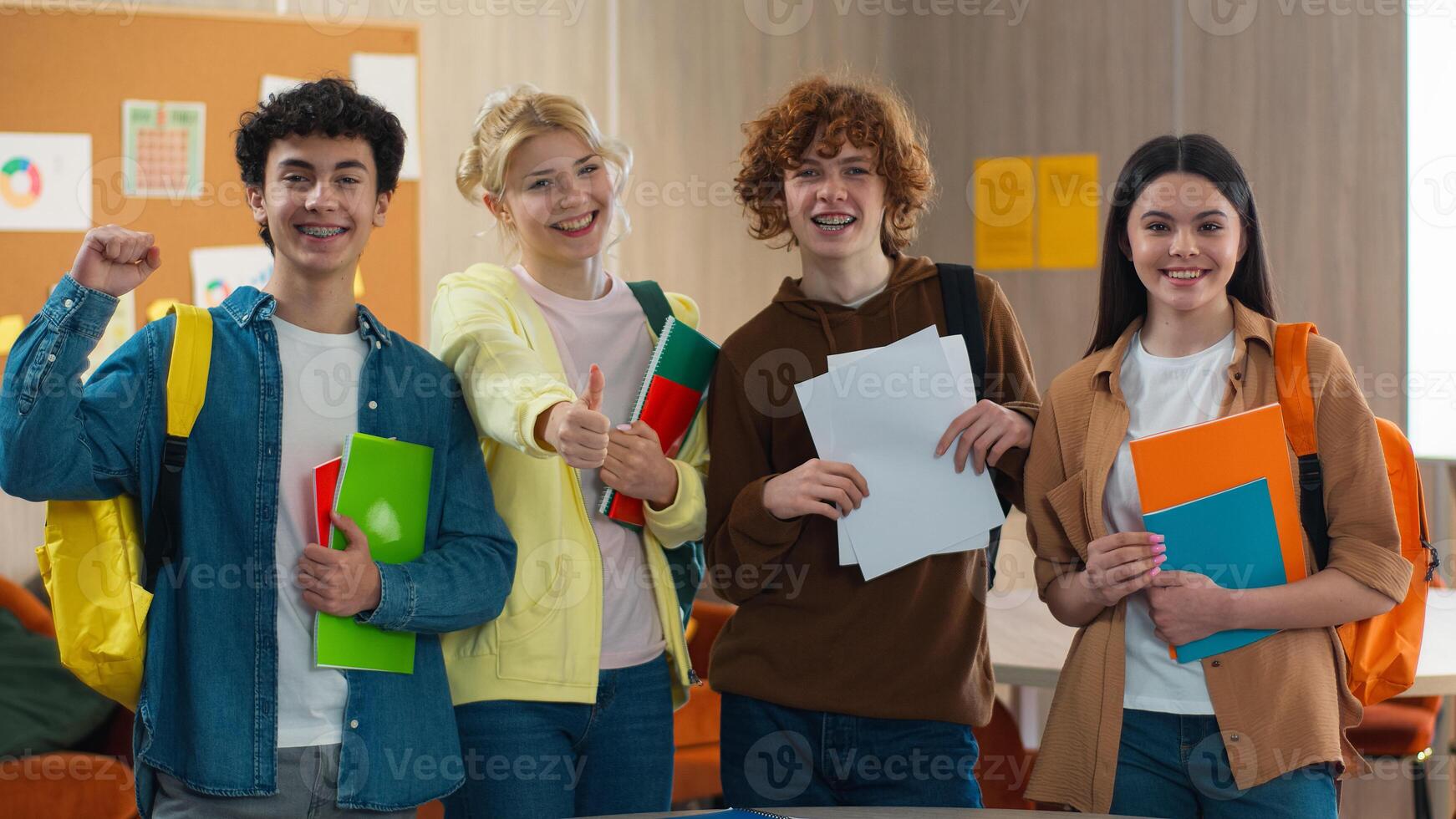 Four school Caucasian students happy smiling rejoice celebrate win victory thumb up good result pass exams pupils studying male female teamwork study learning men women girls guys college excited photo