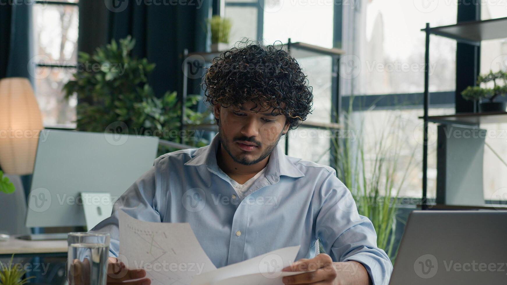 Focused businessman business person accountant office worker writing ideas in notebook paperwork Arabian Indian student write notes data information e-learning with laptop computer educational course photo