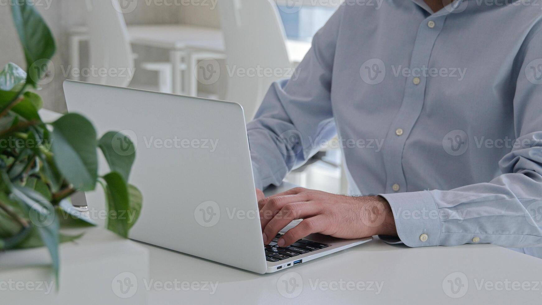Cropped shot Indian Arabian businessman typing laptop working online programming browsing internet computer work at corporate office workplace man entrepreneur manager remote pc studying business deal photo