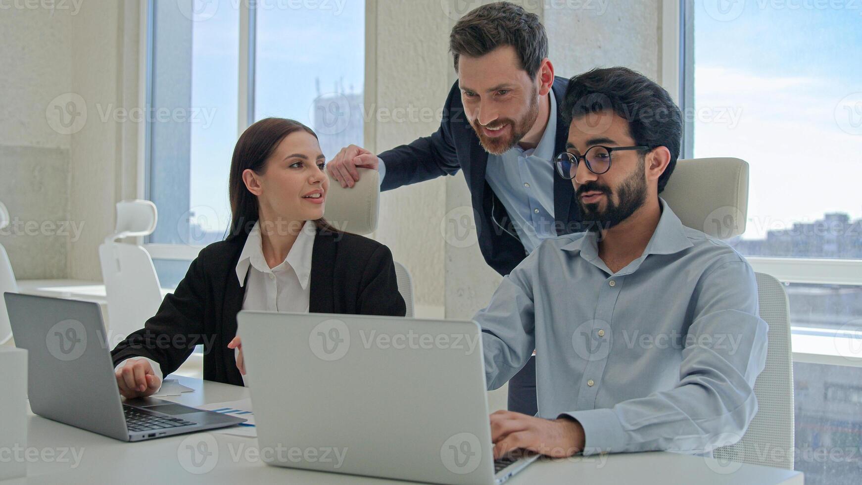 Three happy business people creative team coworkers smiling businessmen businesswoman working together at office company discussing project results mentor teaching office trainees teamwork cooperation photo