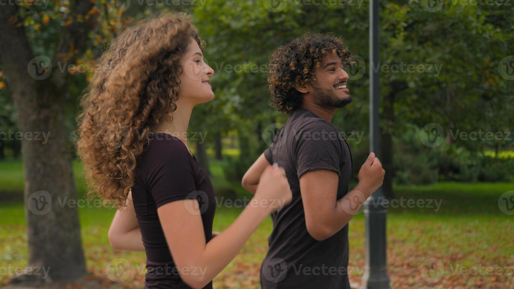 Indian man Caucasian woman multiracial couple friends girl guy happy sport people athletes running together in park outdoors morning run jog healthy workout jogging exercise active lifestyle in city photo