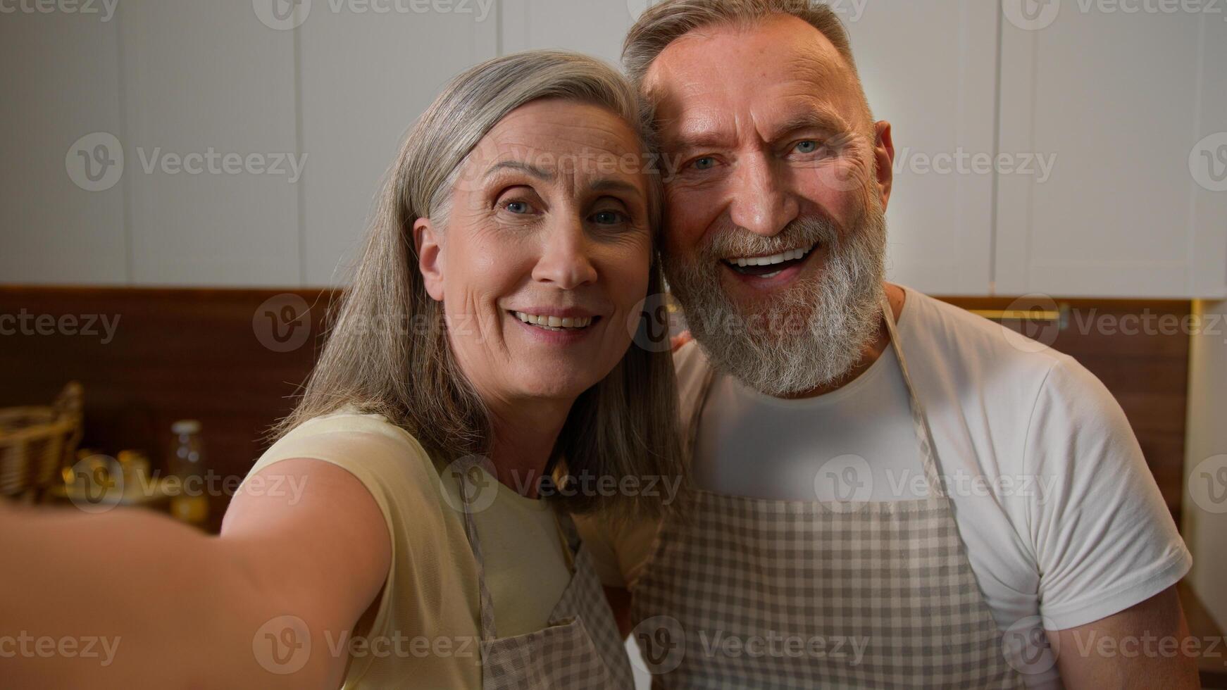 Webcam view happy senior retired family couple chefs record recipe food blog in kitchen old Caucasian grandparents woman and man talk live stream culinary hobby healthy eating love relationship photo