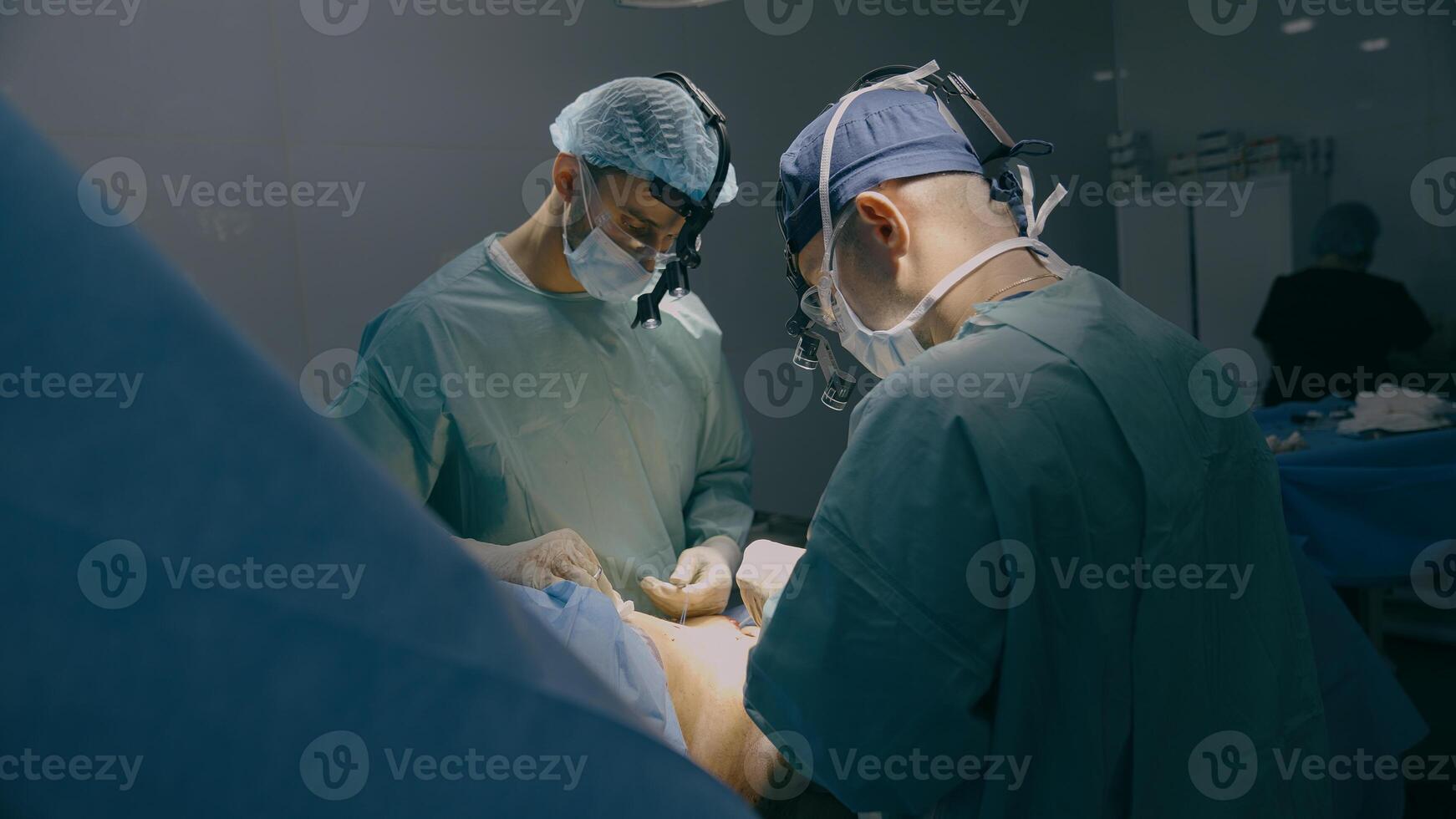 Medical team men doctors surgeons medics processing bariatric surgery stomach belly surgical operation with scalpel illness tumor sore emergency aid treatment hospital clinic health patient medicine photo